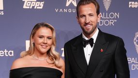 Harry Kane z żoną w eleganckich strojach na niebieskim tle.