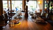 Stół w eleganckiej restauracji, nakryty do posiłku, z widokiem na ogród.