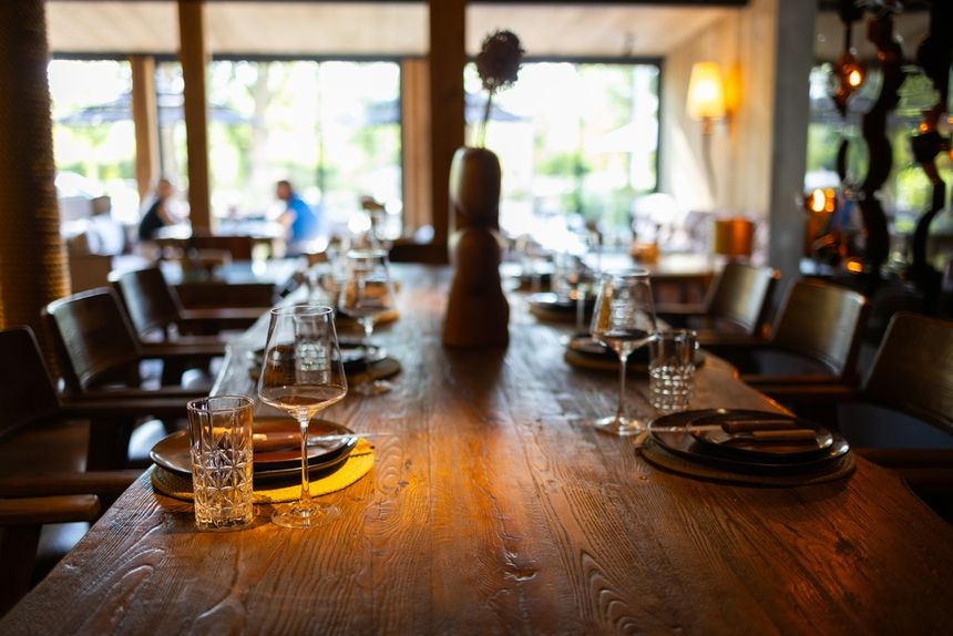Stół w eleganckiej restauracji, nakryty do posiłku, z widokiem na ogród.