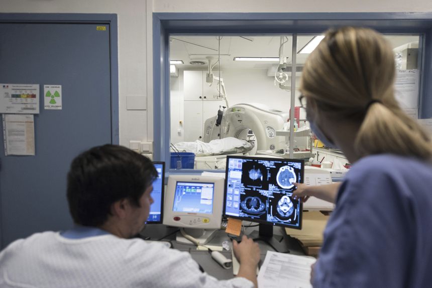 Dwoje pracowników medycznych analizuje wyniki badań w szpitalnym pomieszczeniu.