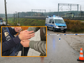 Na zdjęciu: policyjny radiowóz przy torach, zatrzymanie z kajdankami. Deszczowa pogoda.